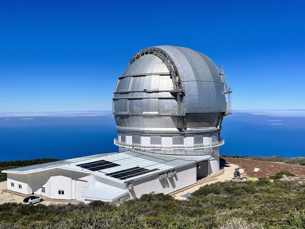 The Gran Telescopio Canarias on La Palma is the largest as it sits in front of a landscape with the ocean