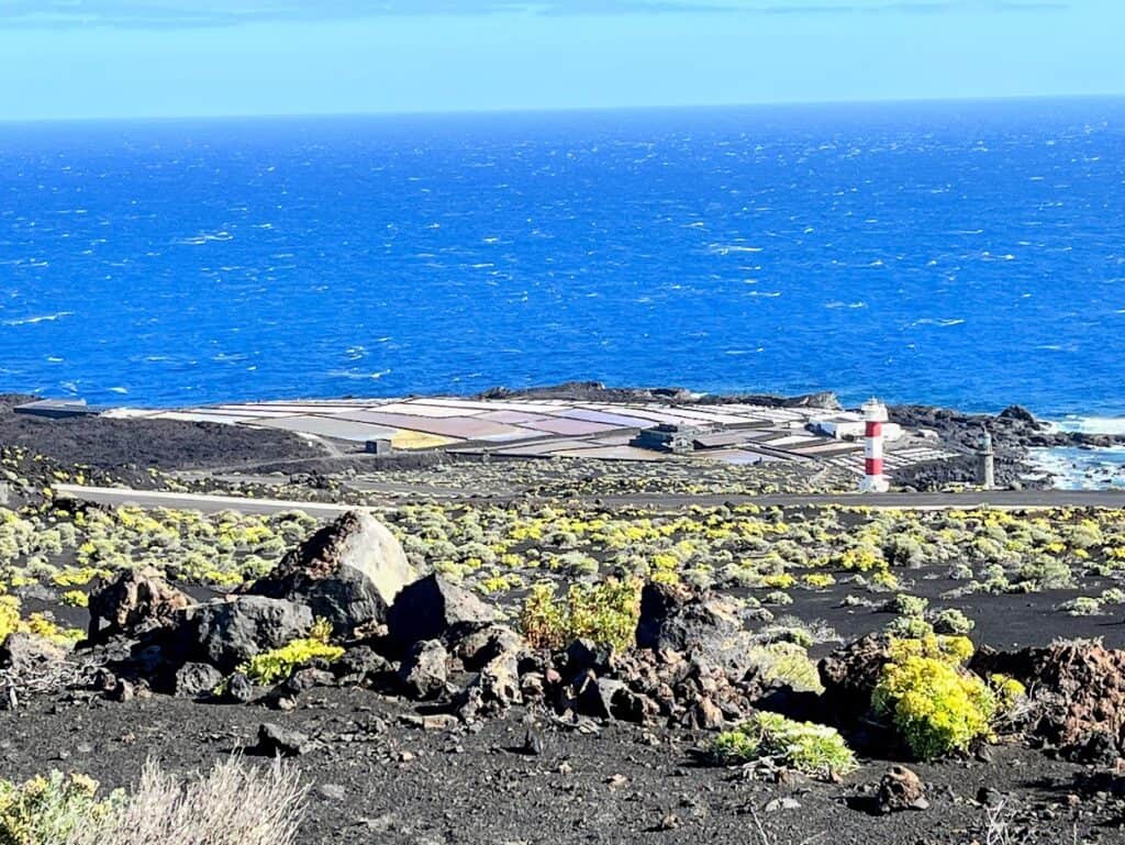 An aerial perspective shows the Salinas de Fuencaliente against the vast blue backdrop of the ocean, a jewel of La Palma, Canary Islands.
