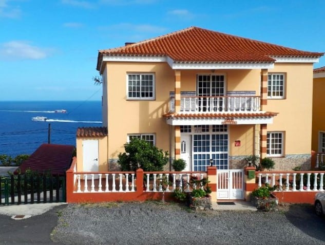 Picture of Apartamentos Casa Junonia, considered one of the best budget hotels in La Gomera, showcasing its cheerful peach exterior and red tile roofing, with balconies offering a stunning view of the deep blue sea, creating an inviting atmosphere for a relaxing island stay.