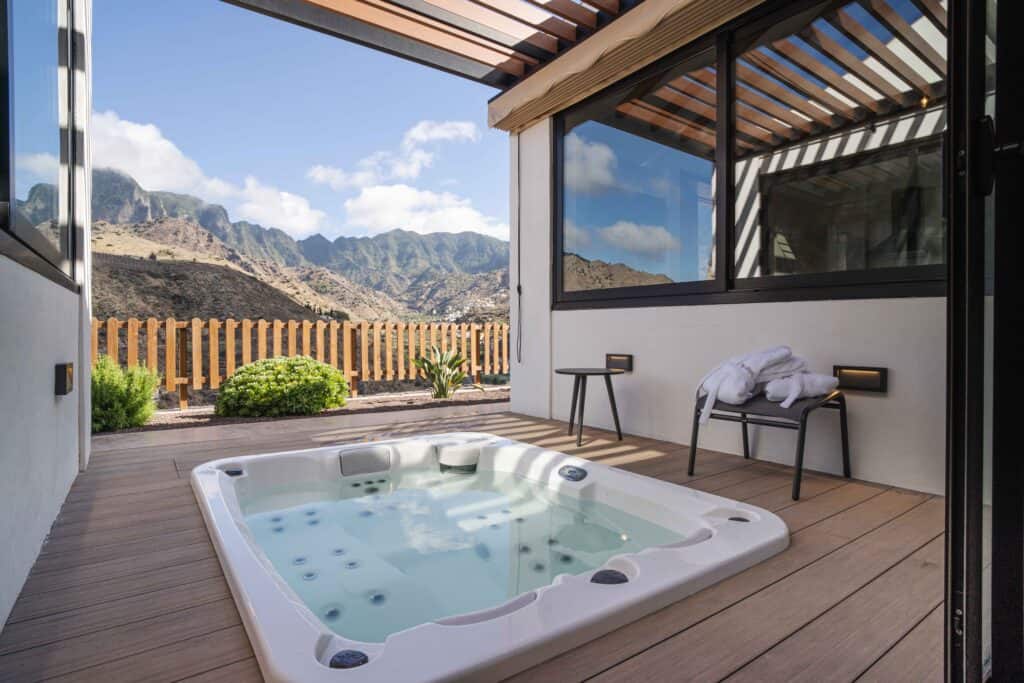 A private hot tub on a wooden deck with a stunning view of the mountainous landscape of Hermigua, offering a serene spot for relaxation at Basalto Casas Rurales.