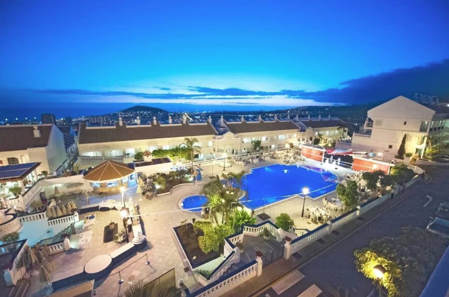 The pool at Hollywood Mirage, one of the best moderate hotels in Los Cristianos, glows beautifully at night with stunning views.