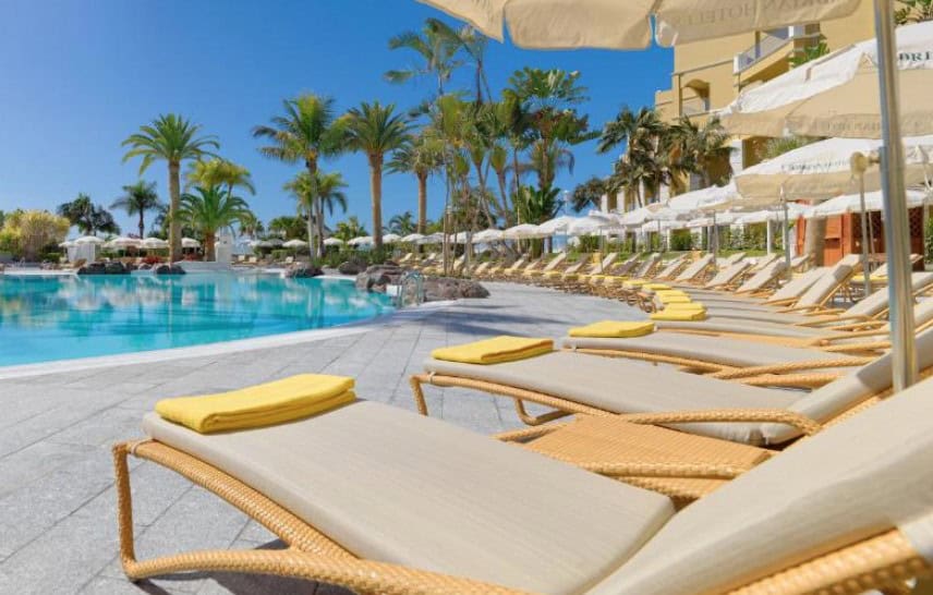 A beautiful pool area with sun loungers and tropical landscaping at Adrián Hoteles Jardines de Nivaria, highlighting the best hotels in South Tenerife.