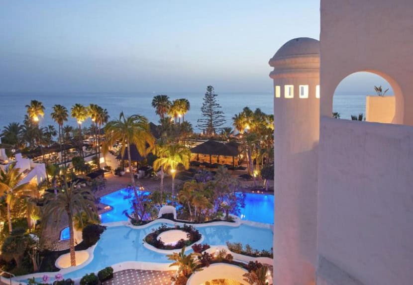 A picturesque view of the pool and ocean at sunset from Dreams Jardin Tropical Resort and Spa, representing the best hotels in Costa Adeje for adults.
