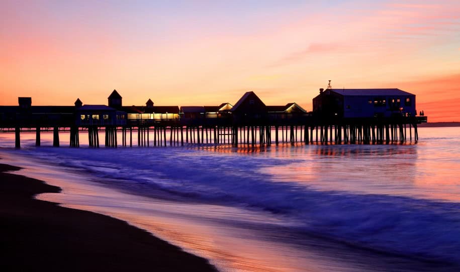 The Old Orchard Beach Pier glows at sunset, a beautiful spot to visit on the drive from Acadia to Boston.