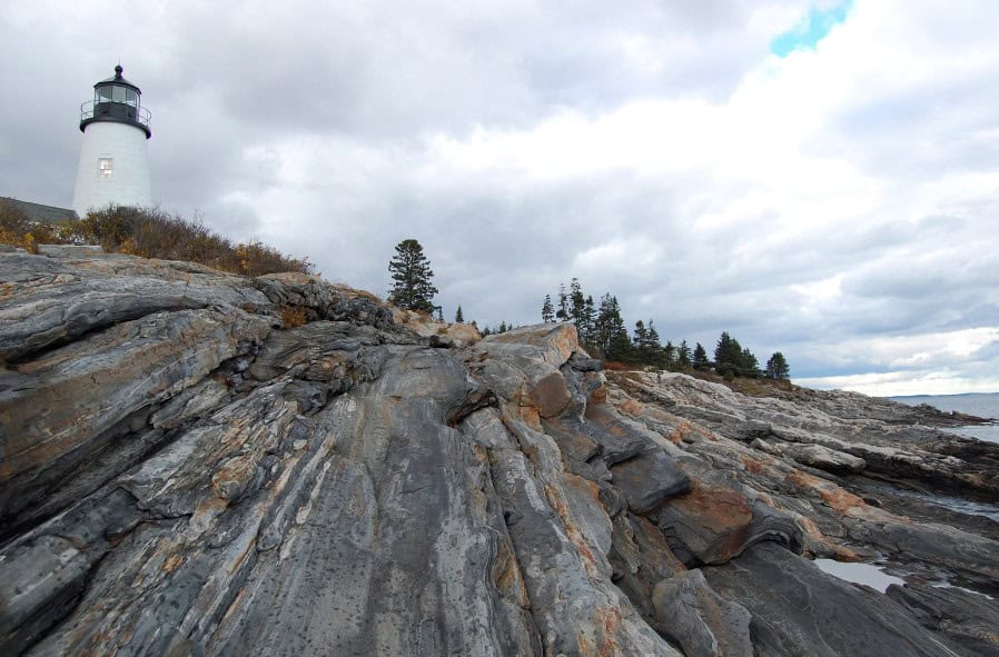 The Pemaquid Point Lighthouse overlooks a rugged, rocky coastline, a scenic destination on the journey from Boston to Acadia.