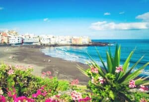 The beautiful black sand beach at Puerto de la Cruz, showcasing why it's one of the best beaches in North Tenerife for a vibrant and relaxing atmosphere.