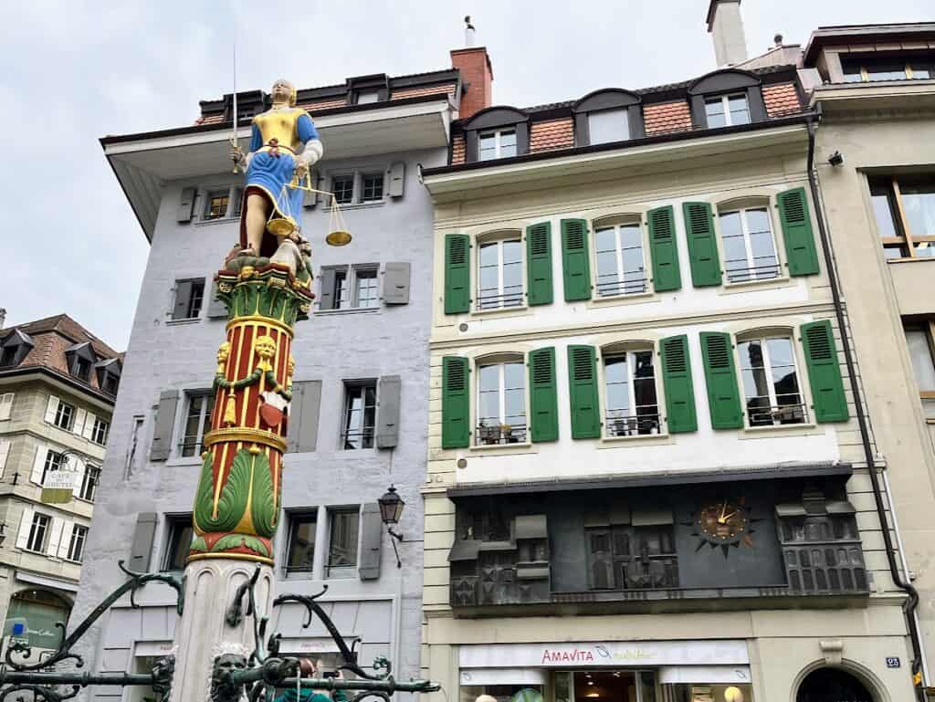 The colorful Fontaine de la Justice in Lausanne’s Place de la Palud features Lady Justice holding a sword and scales, a historical landmark in the Old Town. Exploring this square is one of the top Lake Geneva Switzerland things to do.