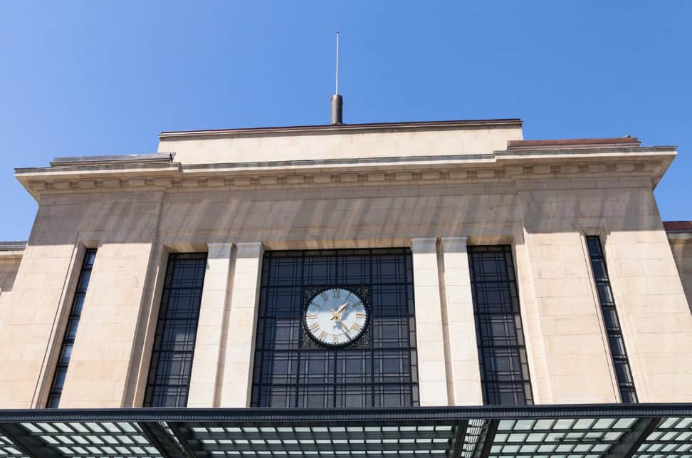 The front facade of Gare Cornavin, Geneva's main train station, featuring the building's classic architecture and prominent clock.