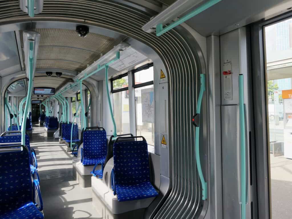 The sleek and modern interior of a Geneva tram, showcasing its comfortable seating and spacious design, perfect for getting around the city during your one day in Geneva.