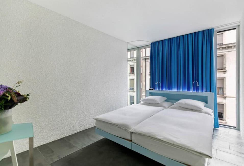 A modern, minimalist room at Hotel Cristal Design in Geneva, offering a sleek design and comfort, perfect for travelers staying near the Geneva train station.