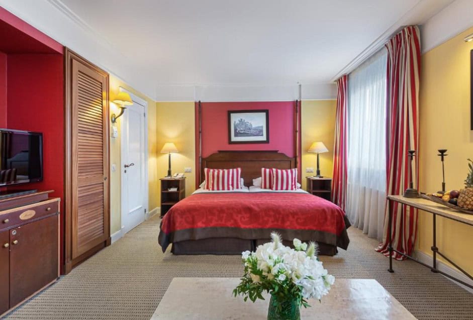 A stylish room at Kipling Manotel in Geneva, featuring unique Indian-inspired decor and comfortable amenities, located just a short walk from Geneva main train station.