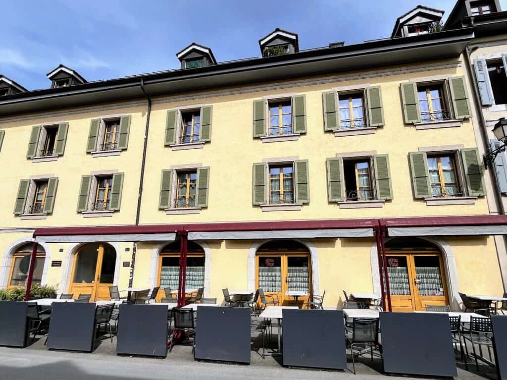 The charming exterior of Le Dix Vins, a cozy French restaurant located in the Carouge district of Geneva, Switzerland. The restaurant's outdoor seating and traditional architecture make it a perfect dining spot during your two days in Geneva.