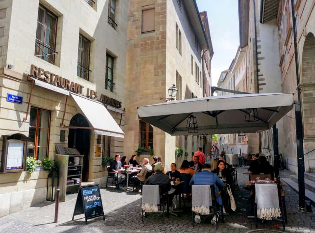 Outdoor seating at Restaurant Les Armures, a charming place to enjoy a traditional Swiss meal during your 1 day in Geneva.