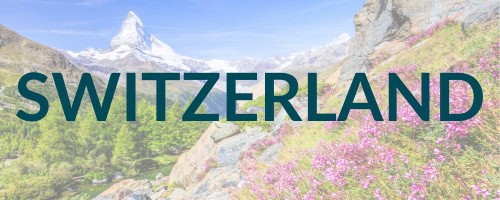 The word "SWITZERLAND" in bold, green letters overlaying a beautiful landscape with the iconic Matterhorn mountain in the background, lush green trees, and blooming pink flowers in the foreground.