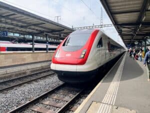 A modern, sleek train stationed at Geneva’s main train station (Gare de Genève), ready to depart. The train is a popular and comfortable option for travelers staying at hotels near Geneva Train Station, offering a smooth and scenic ride through the picturesque countryside.