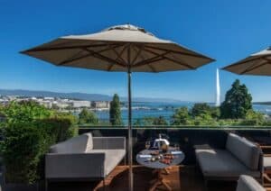 The stunning rooftop terrace at Hôtel Métropole Genève, offering spectacular views of Lake Geneva and the Jet d'Eau fountain. A perfect spot to enjoy the best of Geneva hotels on the lake with a drink at sunset