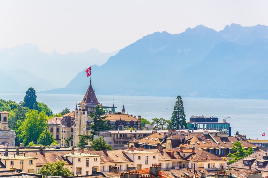 A beautiful aerial view of Lausanne with Lake Geneva and the Swiss Alps in the background. One of the top reasons to visit Lausanne is its breathtaking scenery. Wondering is Lausanne worth visiting? This view alone answers that question.