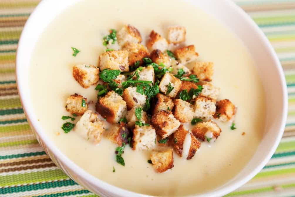 A hearty bowl of chestnut soup topped with crispy croutons and fresh herbs, offering a rich, savory flavor ideal for a cozy meal in Zermatt, Switzerland.